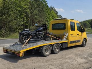 Motocykl zapięty na platformie lawety w letni dzień – Pabianice
